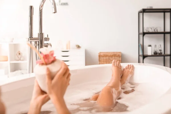 Mooie jonge vrouw met tropische cocktail ontspannen in bad — Stockfoto