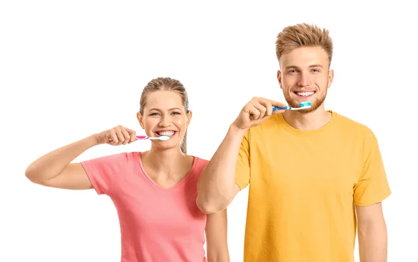 Young couple brushing teeth on white background — Stock Photo, Image