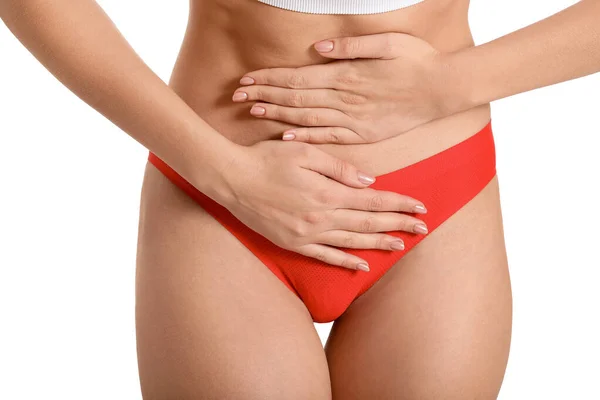 Mujer joven que sufre de dolor abdominal sobre fondo blanco. Concepto ginecológico — Foto de Stock