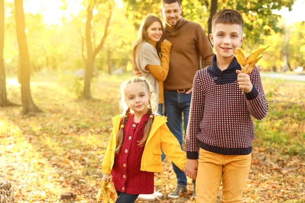 Счастливые дети с родителями отдыхают в осеннем парке — стоковое фото