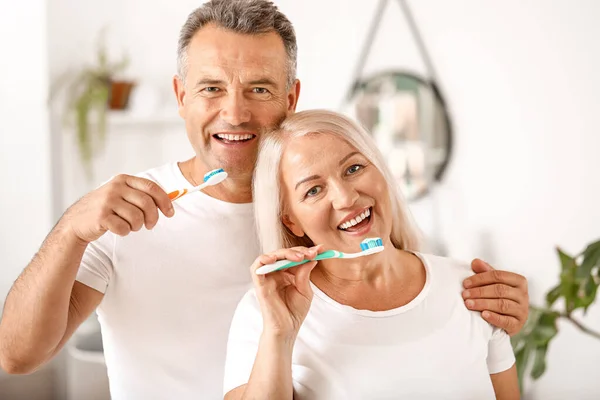 Mature couple brushing teeth at home — Stock Photo, Image
