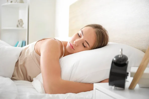 Morgon när en ung kvinna sover i sängen — Stockfoto
