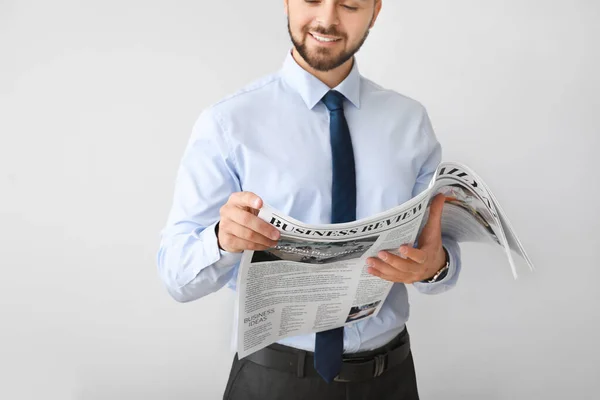 Hombre de negocios guapo con periódico sobre fondo claro — Foto de Stock