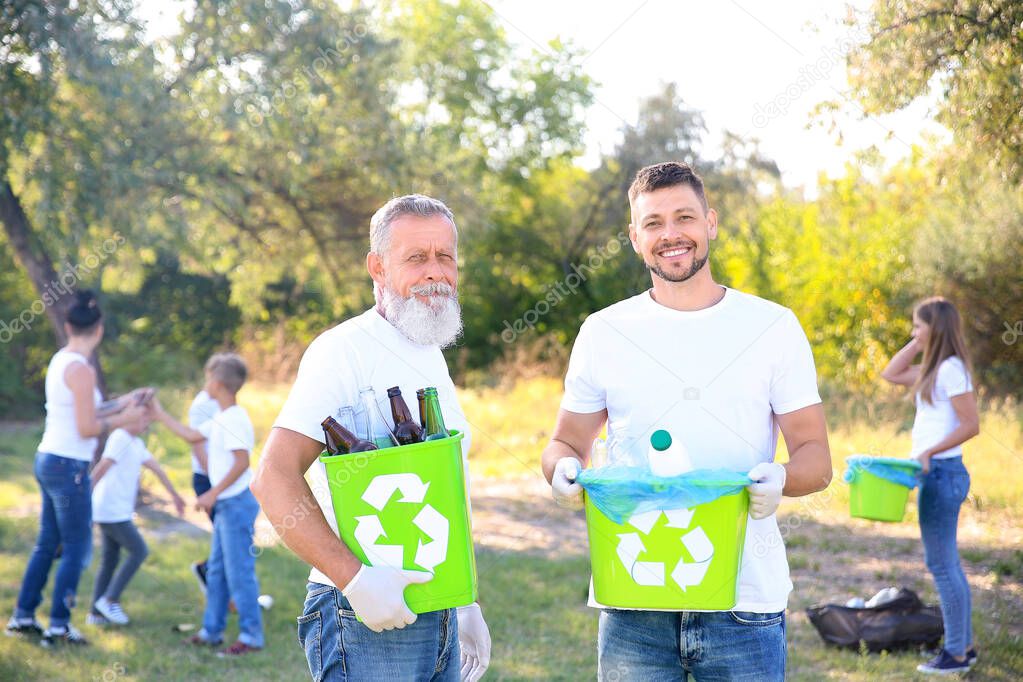 Men with gathered garbage outdoors. Concept of recycling