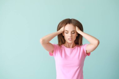 Genç kadın renk arka plan üzerinde baş ağrısı muzdarip