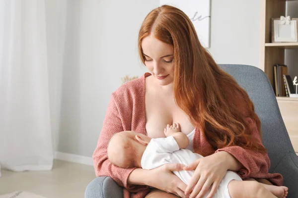 Giovane donna che allatta il suo bambino a casa — Foto Stock