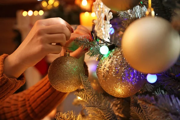 Woman decorating Christmas tree at home in evening — Stock Photo, Image