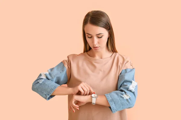 Hermosa mujer joven con reloj sobre fondo de color —  Fotos de Stock