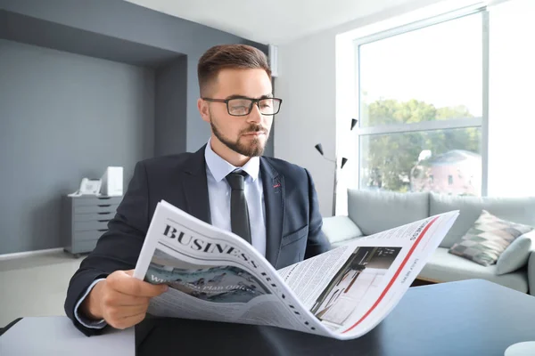 Hombre de negocios guapo leyendo el periódico en la oficina — Foto de Stock