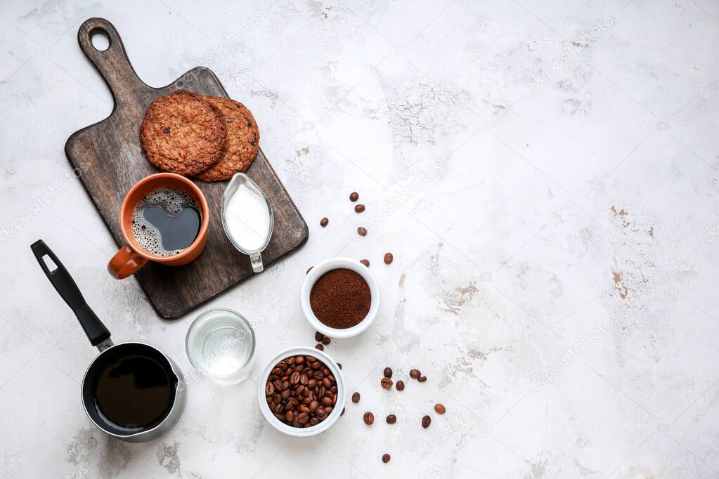 Cup of hot coffee with milk and cookies on light background