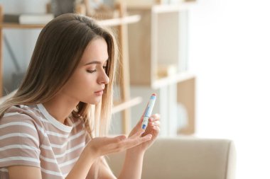 Diyabetik kadın evde kan şekeri seviyesini kontrol