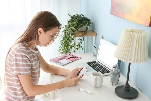 Diabetic woman checking blood sugar level at home — Stock Photo, Image