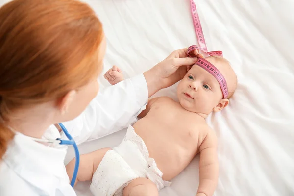 Kinderarts onderzoekt schattige baby in kliniek — Stockfoto