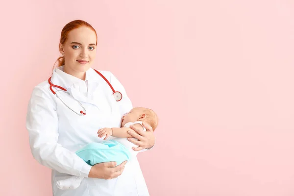 Pediatrician with cute baby on color background — Stock Photo, Image