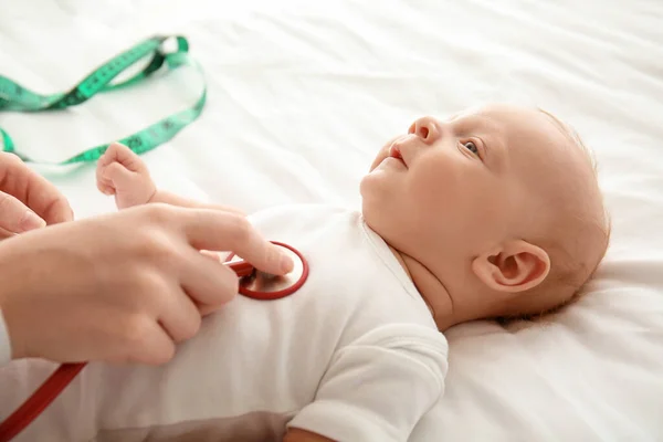 Pediatrician examining cute baby in clinic, closeup — Stock Photo, Image