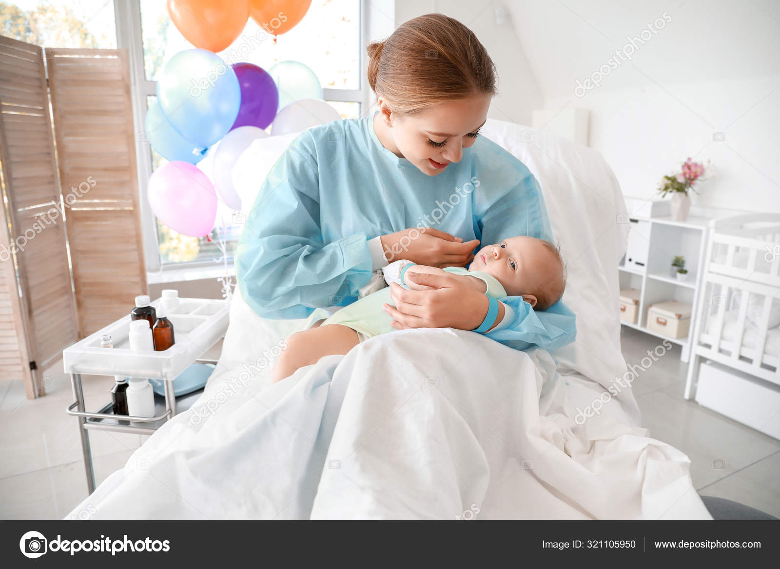 Young mother with newborn baby in maternity hospital — Stock Photo