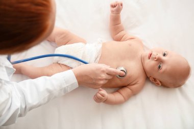Pediyatrist klinikte şirin bebeği muayene ediyor.
