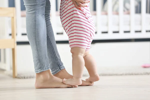 Mother teaching her little baby to walk at home — Stock Photo, Image