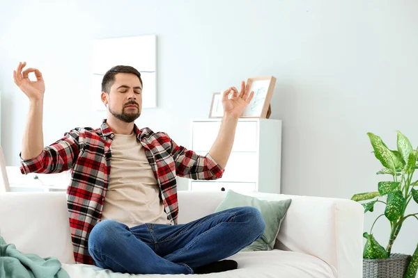 Handsome man meditating at home — Stock Photo, Image