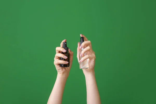 Female hands with different cosmetic products in bottles on color background — Stock Photo, Image