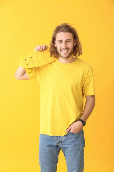 Portrait of happy man with skateboard on color background — Stock Photo, Image