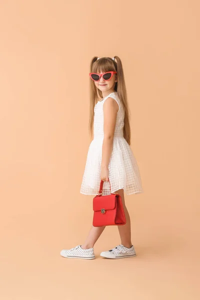 Módní malá holčička na barvu pozadí — Stock fotografie