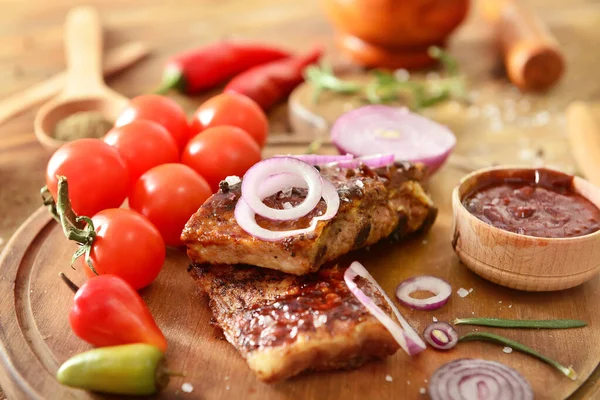 Viande grillée savoureuse avec sauce barbecue, légumes et épices sur la table — Photo