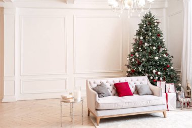 İçinde güzel süslenmiş Noel ağacı olan odanın içi.
