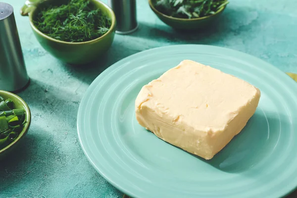 Plate with fresh butter and herbs on table — Stock Photo, Image