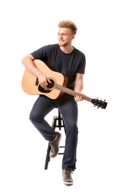 Beyaz arka planda gitarı olan yakışıklı bir adam.