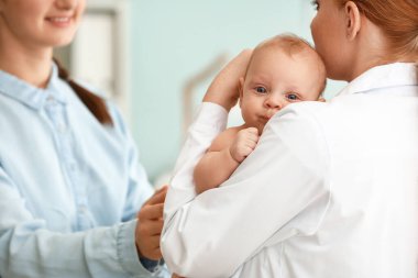 Küçük bebek li kadın klinikte çocuk doktorunu ziyaret etti