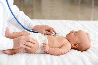 Pediyatrist klinikte şirin bebeği muayene ediyor.