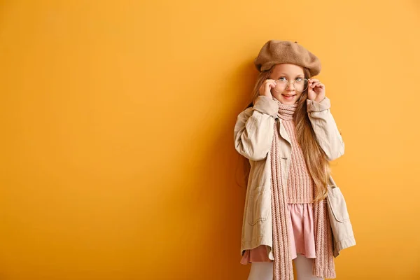 Модна маленька дівчинка в осінньому одязі на кольоровому фоні — стокове фото