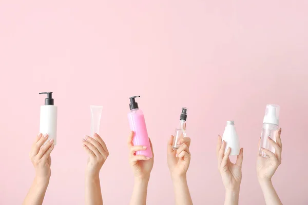 女性の手で異なる化粧品製品でボトルの色背景 — ストック写真