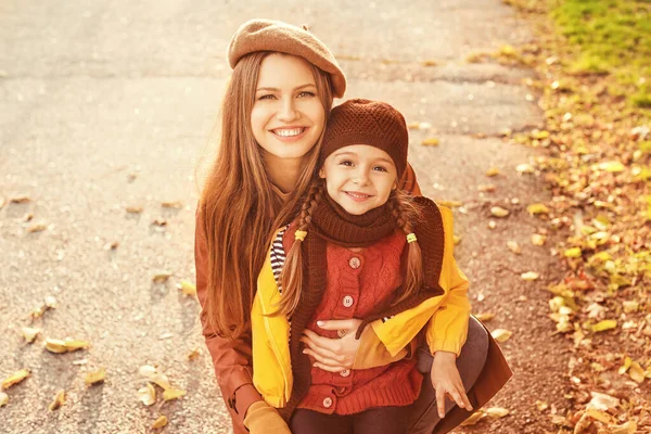 Happy mother and daughter in autumn park — Stock Photo, Image