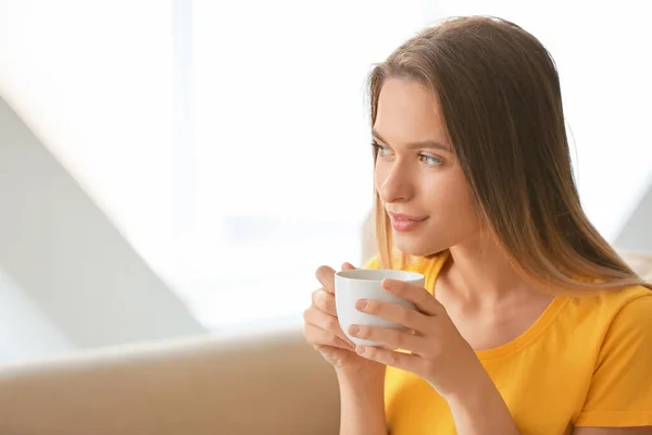 Mujer joven con taza de café descansando en casa — Foto de Stock
