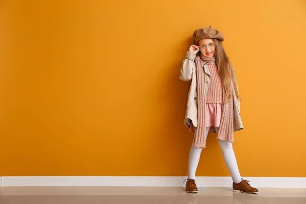 Modieus klein meisje in de herfst kleding in de buurt van kleur muur — Stockfoto