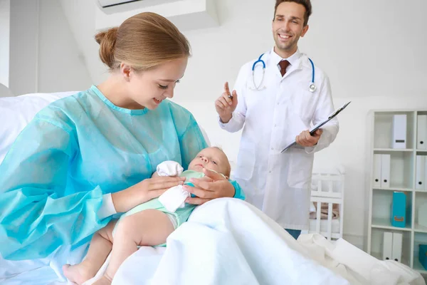 Jovem com bebê recém-nascido e ginecologista na maternidade — Fotografia de Stock