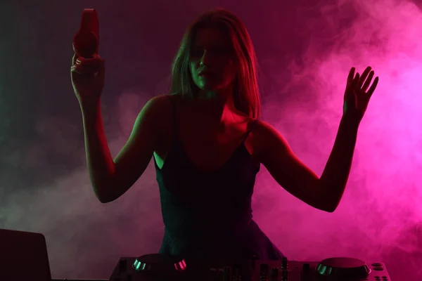 나이트 클럽에서 음악을 연주하는 여성 DJ 의 실루엣 — 스톡 사진