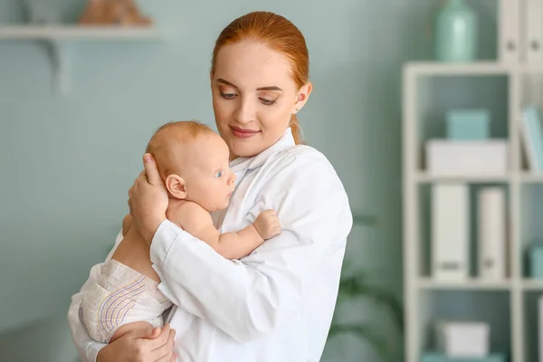 Pediatra con lindo bebé en la clínica —  Fotos de Stock