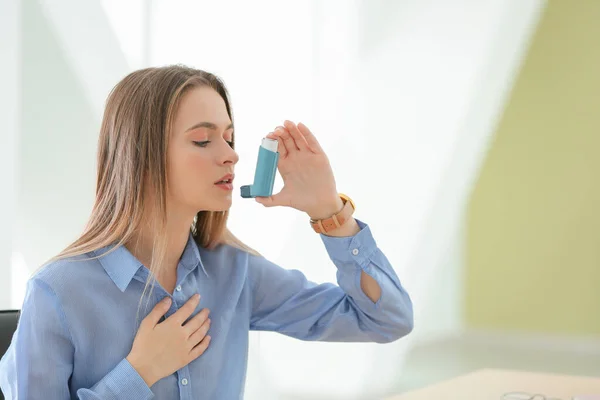Jovem com inalador tendo ataque de asma no escritório — Fotografia de Stock