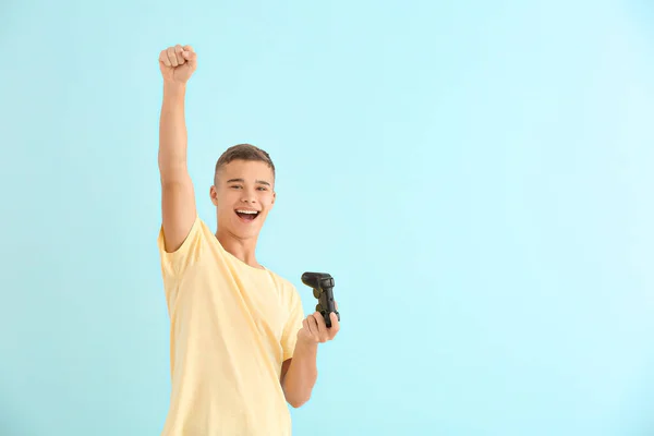 Happy teenager boy with game pad on light background — Stock Photo, Image