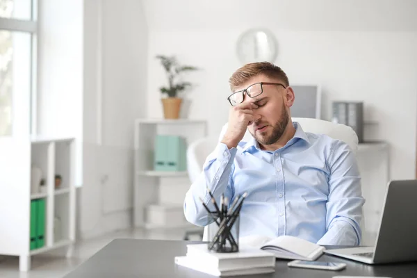 Jongeman met hoofdpijn op kantoor — Stockfoto