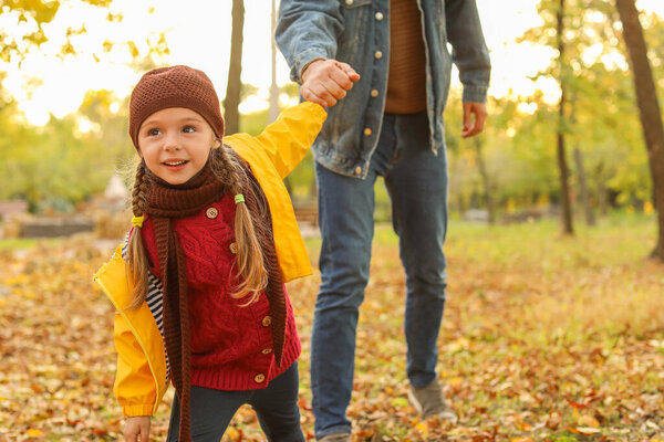 Happy girl with father having fun in autumn park