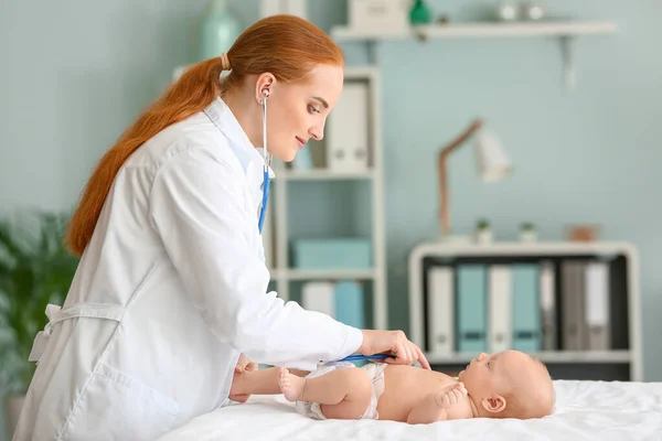 Kinderarts onderzoekt schattige baby in kliniek — Stockfoto