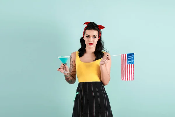 Portrait de belle femme tatouée pin-up avec drapeau des États-Unis et cocktail sur fond de couleur — Photo