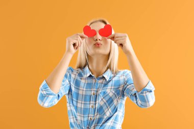 Renkli arka planda küçük kırmızı kalpleri olan güzel genç bir kadın.