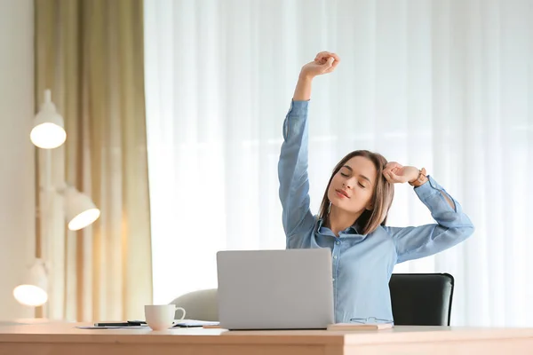 Mujer cansada estirando las manos mientras trabaja en la oficina —  Fotos de Stock