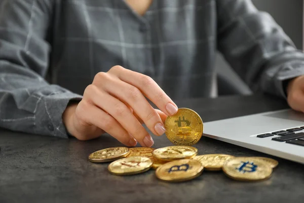 Businesswoman with bitcoins and laptop at table — Stock Photo, Image