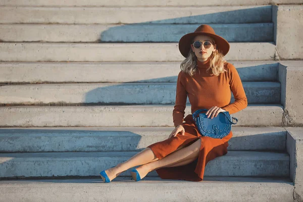 Portrait of fashionable young woman sitting on steps outdoors — Stockfoto